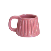 Handcrafted ceramic mug with an iridescent blush pink glaze, featuring a soft, rounded form and a comfortable handle. A warm, rosy glow that brings charm and calm to every sip.