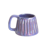 Handcrafted ceramic mug with an iridescent glaze in layered sea tones of blue and green, echoing ocean waves. Its organic shape and curved handle bring a calming, coastal vibe to every sip.