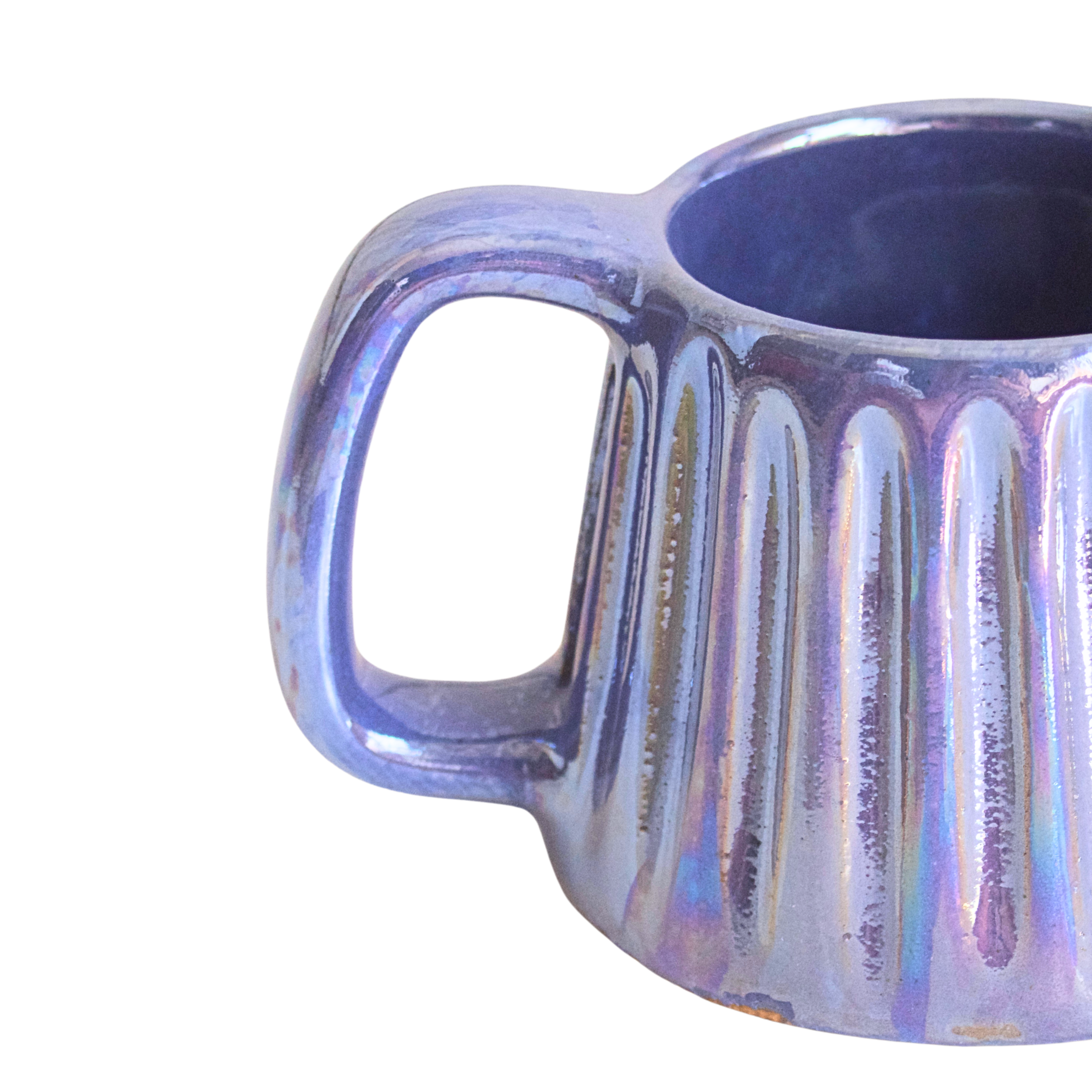 Handcrafted ceramic mug with an iridescent glaze in layered sea tones of blue and green, echoing ocean waves. Its organic shape and curved handle bring a calming, coastal vibe to every sip.


